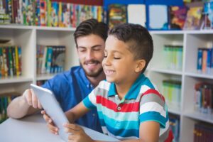 Teacher and school kid using digital table in library 786186
